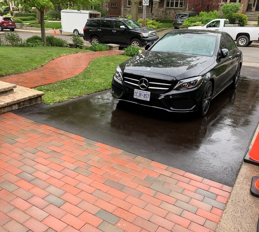 A driveway with a car, displaying asphalt work done by GSI contracting